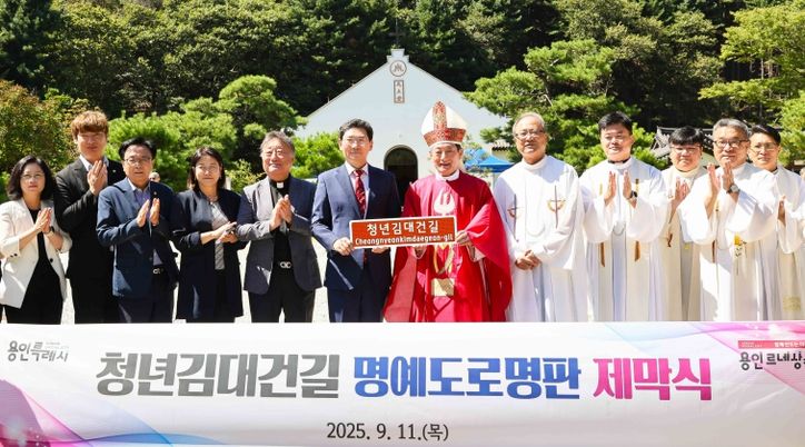 이상일 용인특례시장과 문희종 요한세례자 수원교구 총대리 주교가 청년김대건길 명예도로명판을 들고 기념촬영하고 있다