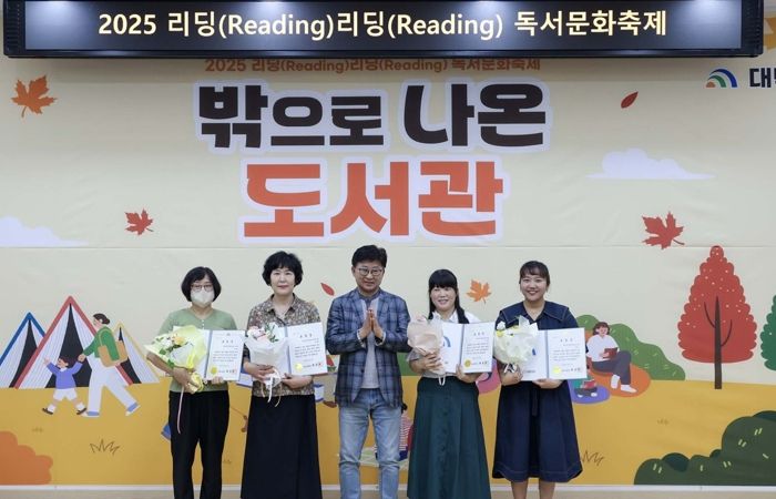 최충규 대덕구청장(사진 가운데)이 13일 안산도서관과 안산공원에서 열린 ‘2025년 리딩(Reading) 리딩(Reading) 독서문화축제’에 참석해 독서문화 확산과 도서관 자원봉사에 기여한 주민에게 ‘독서유공자 표창’을 수여한 후 기념 촬영을 하고 있다.