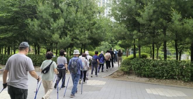 지난 하남88워킹 1기 프로그램 현장 모습. 참가자들이 강사의 지도 아래 노르딕 워킹 및 근력 강화 운동 실습을 하고 있다.