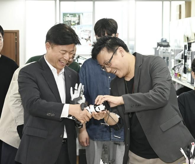 ㈜만드로의 이상호 대표가 조용익 부천시장에게 전자의수를 보여주고 있다.