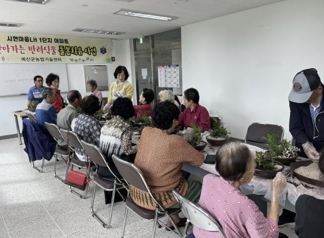 예산 시현 LH1단지 아파트에서 진미녀 강사로부터 화분 심기 및 병해충 관리 교육을 받는 어르신들