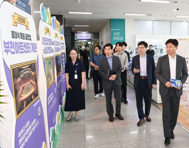 조용익 부천시장(오른쪽)이 ‘기본을 심다, 혁신이 피어나다’를 주제로 열린 ‘혁신·적극행정 우수사례 전시회’를 둘러보고 있다.