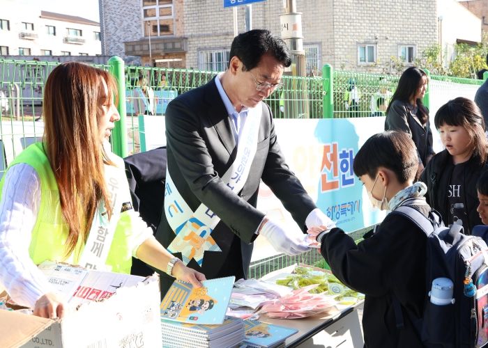 22일 장안초등학교 앞에서 열린 스쿨존 교통안전 캠페인에서 정명근 화성특례시장이 어린이들에게 교통안전수칙 홍보물을 나눠주고 있다