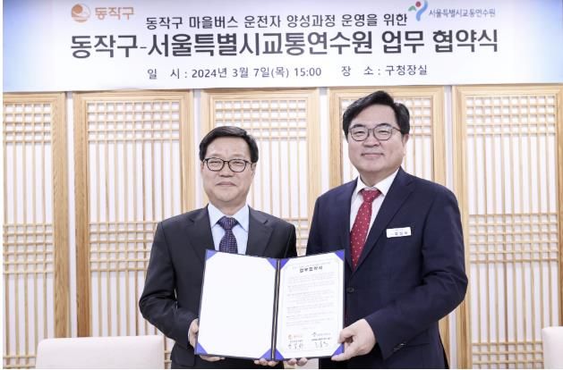 박일하 동작구청장(오른쪽)이 지난해 3월 고홍석 서울시 교통연수원장(왼쪽)과 업무협약을 체결한 후 기념 촬영하고 있다.