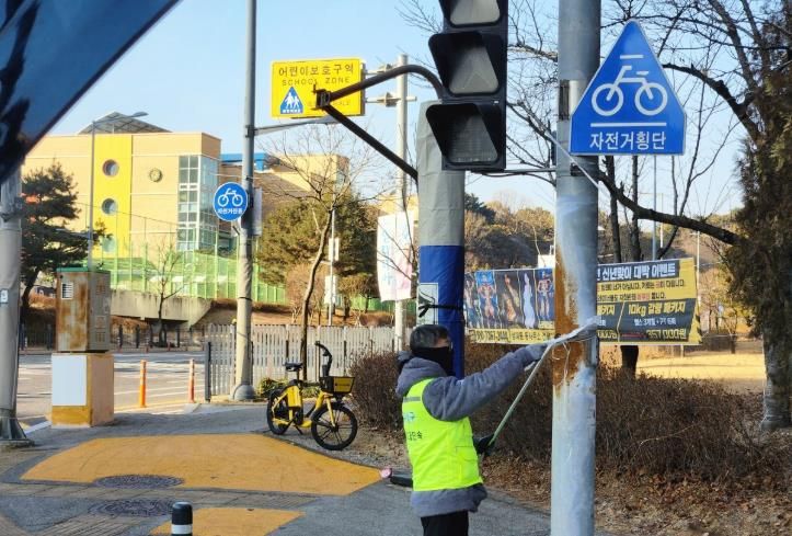 유성구청 직원이 어린이 보호구역 내의 불법광고물을 정비하고 있다