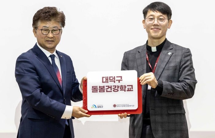 최충규 대덕구청장과 서용원 대덕구장애인종합복지관 관장이 12일 대덕구장애인종합복지관에서 열린 ‘돌봄건강학교 입학식’에서 현판을 들고 기념촬영을 하고 있다.