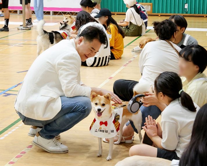오언석 도봉구청장(가운데)이 반려견 동반 방범대 선포식에서 구민의 반려견을 쓰다듬고 있다